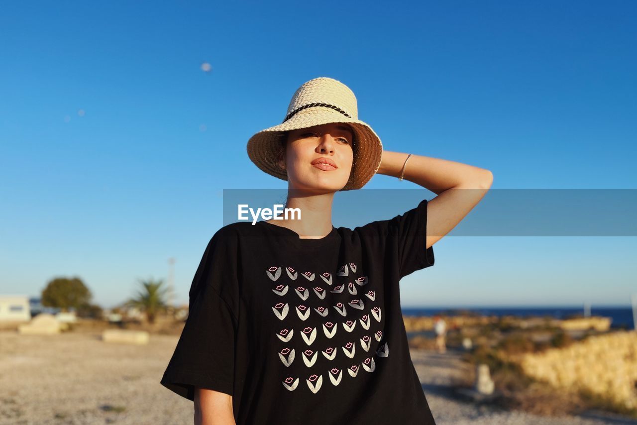 Portrait of young woman standing at beach