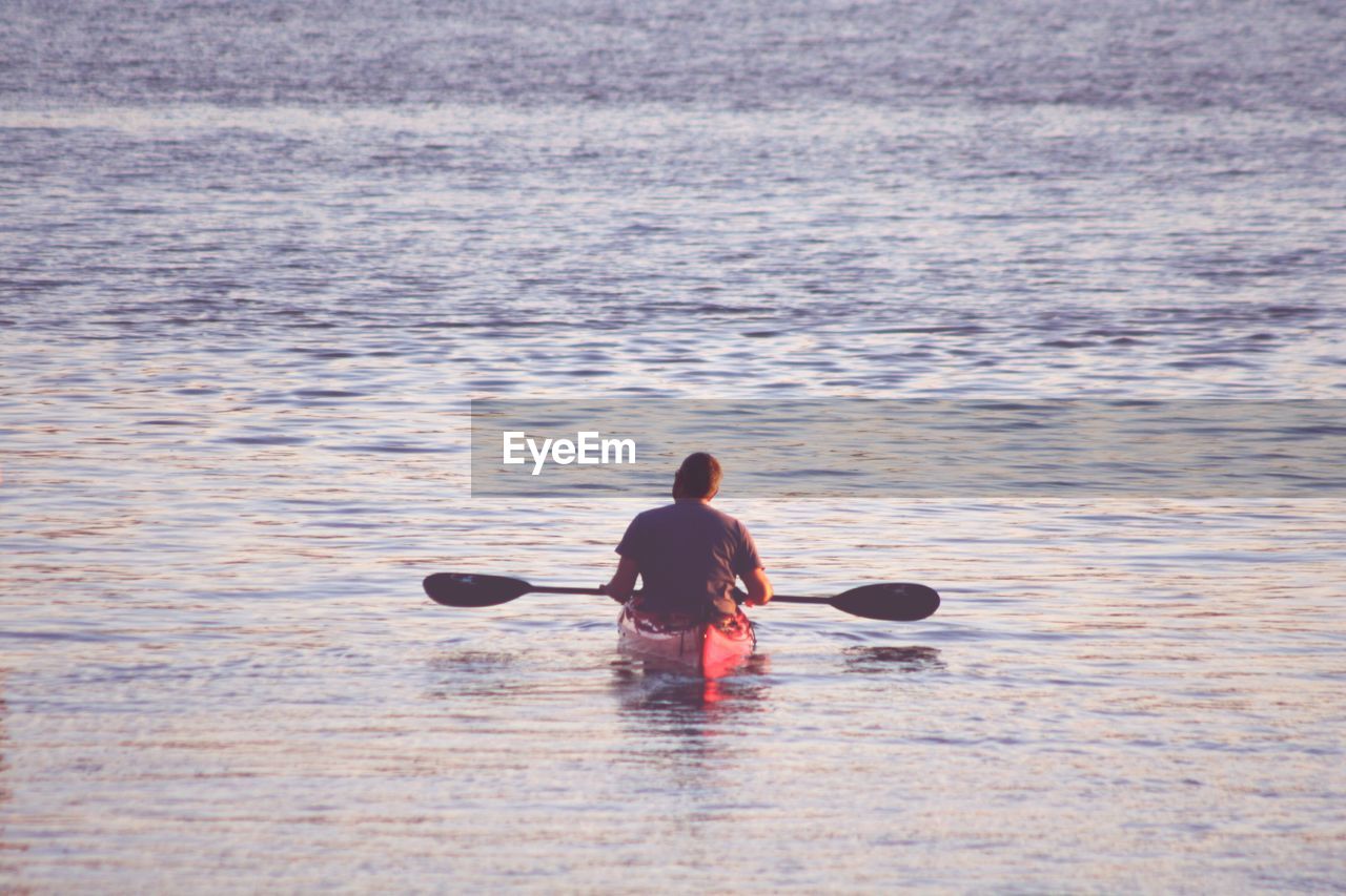 Rear view of man kayaking in sea