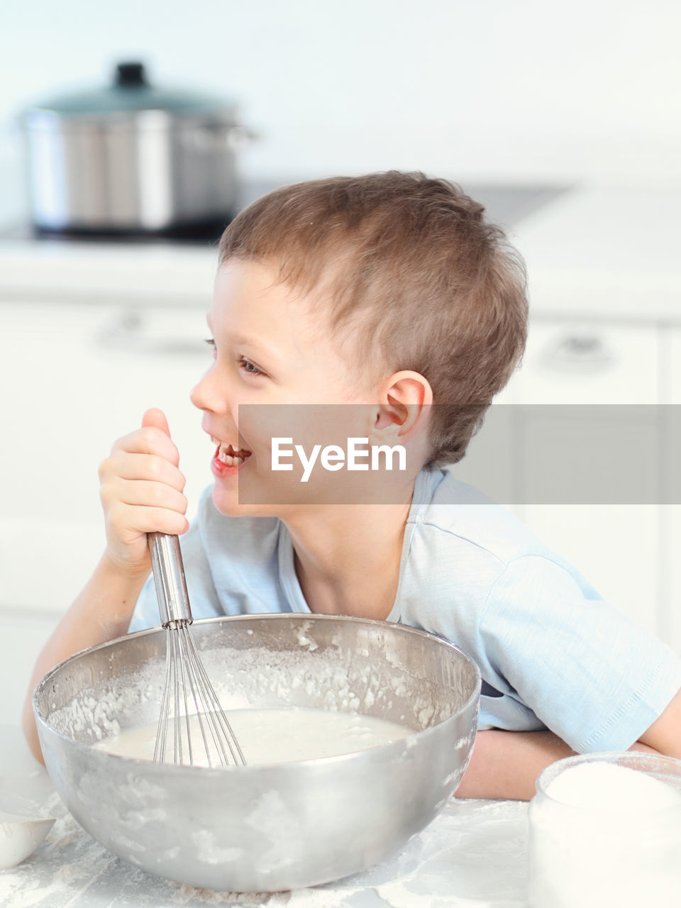 portrait of cute boy eating food in kitchen