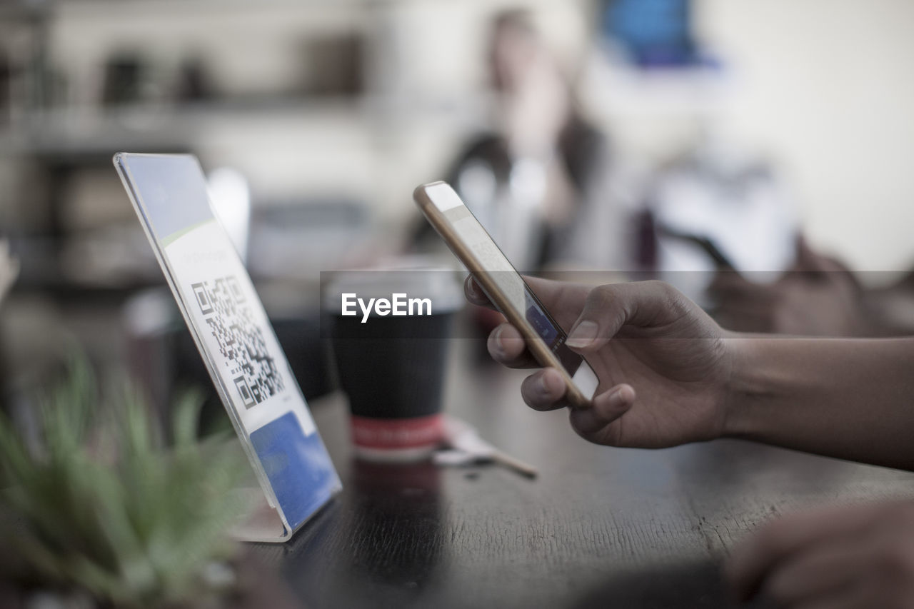 Hand holding smart phone, scanning barcode