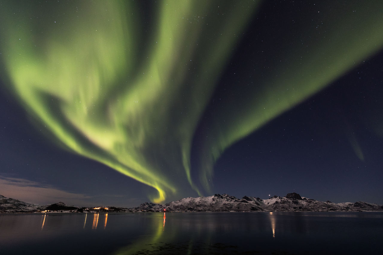 Scenic view of aurora borealis over lake at night