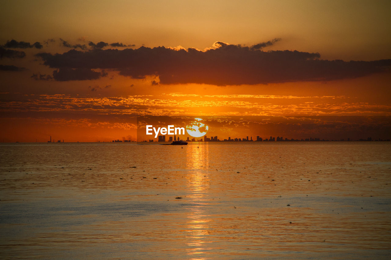 Scenic view of sea against orange sky