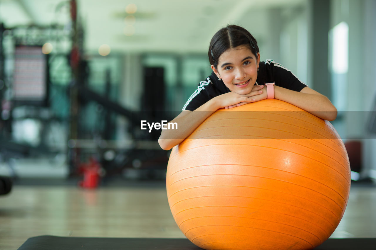 Portrait of girl with fitness ball at gym