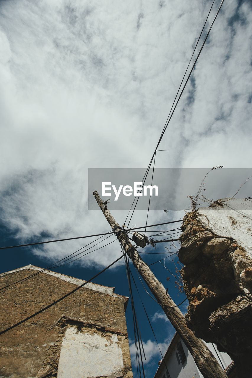 LOW ANGLE VIEW OF POWER LINES AGAINST CLOUDY SKY