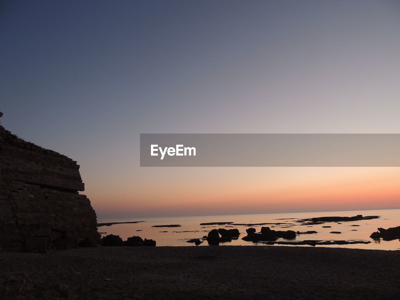 Scenic view of sea against clear sky during sunset