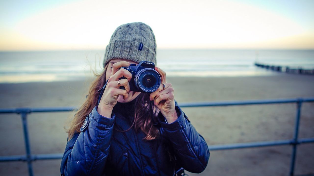 PORTRAIT OF WOMAN PHOTOGRAPHING SEA