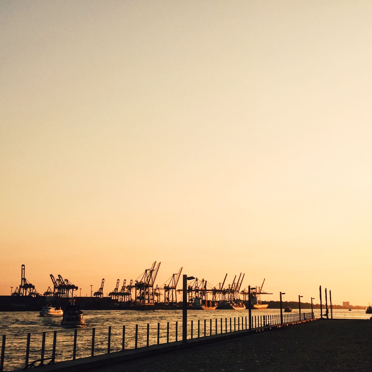 Pier over sea against clear sky during sunset