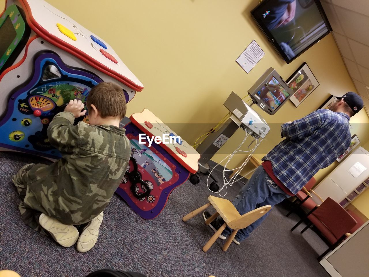 REAR VIEW OF BOY WITH TOY TOYS IN BEDROOM