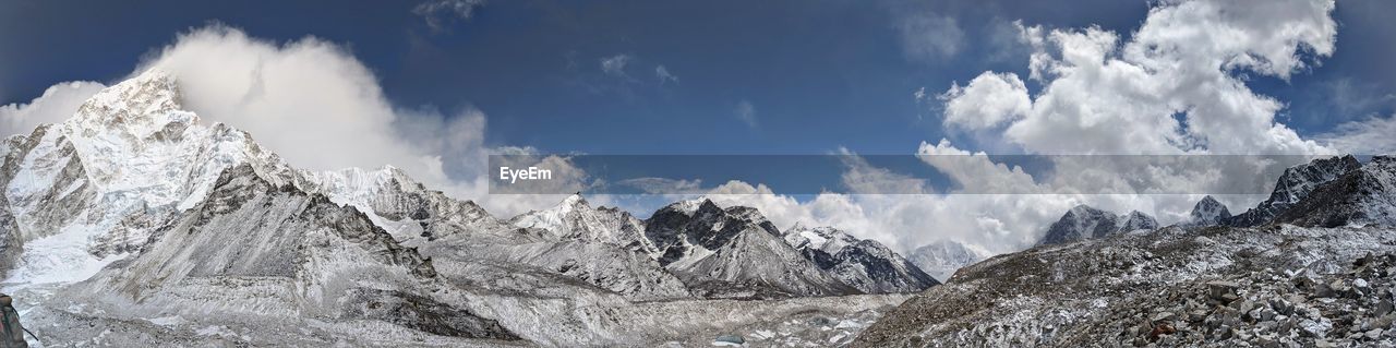Panoramic view of snow covered mountains against sky