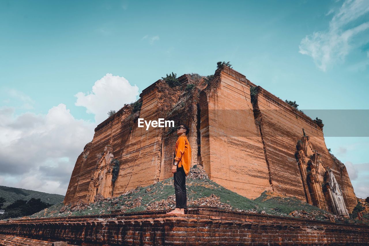 Low angle view of man standing on temple against sky