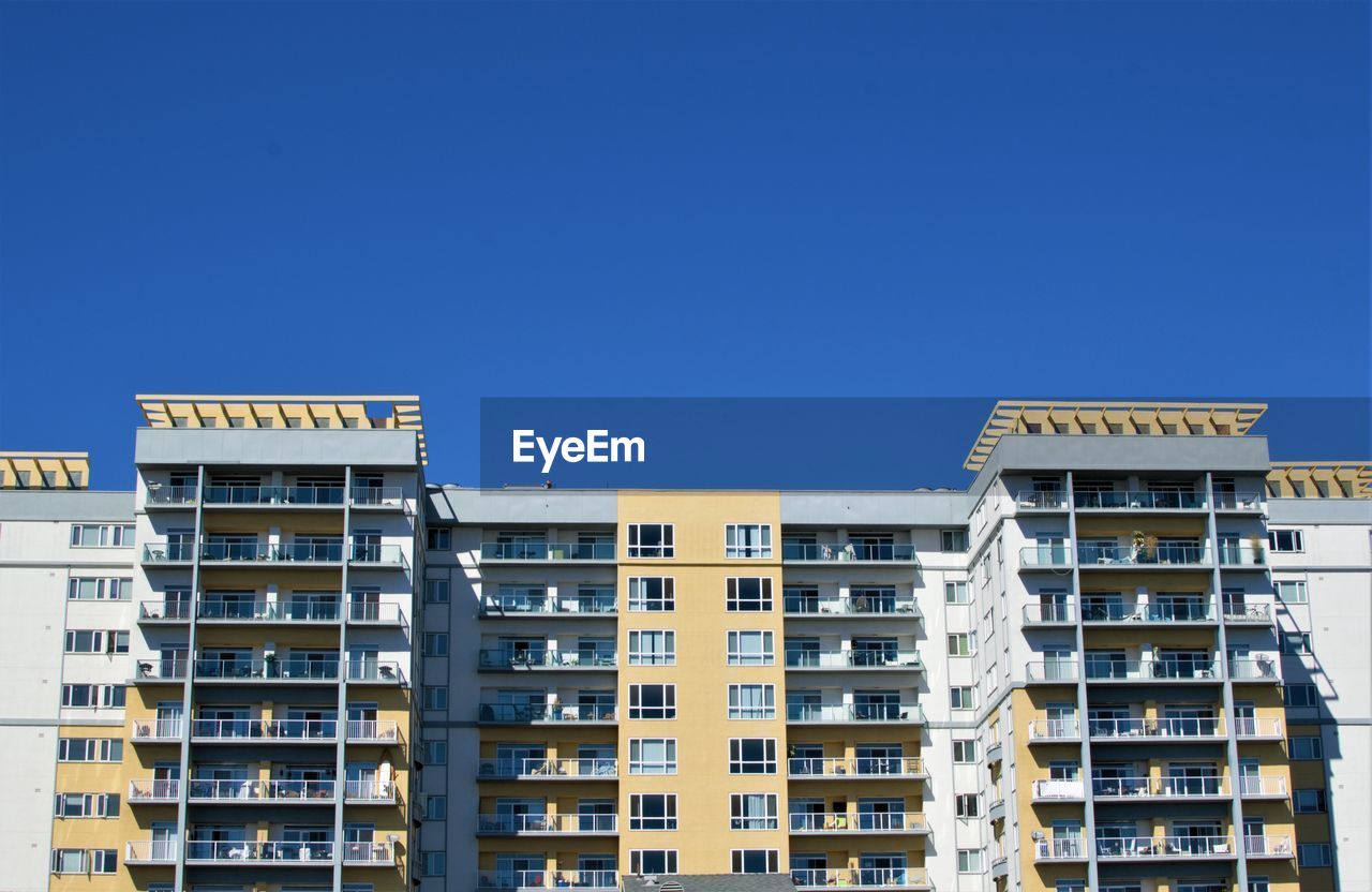 Low angle view of buildings against clear blue sky