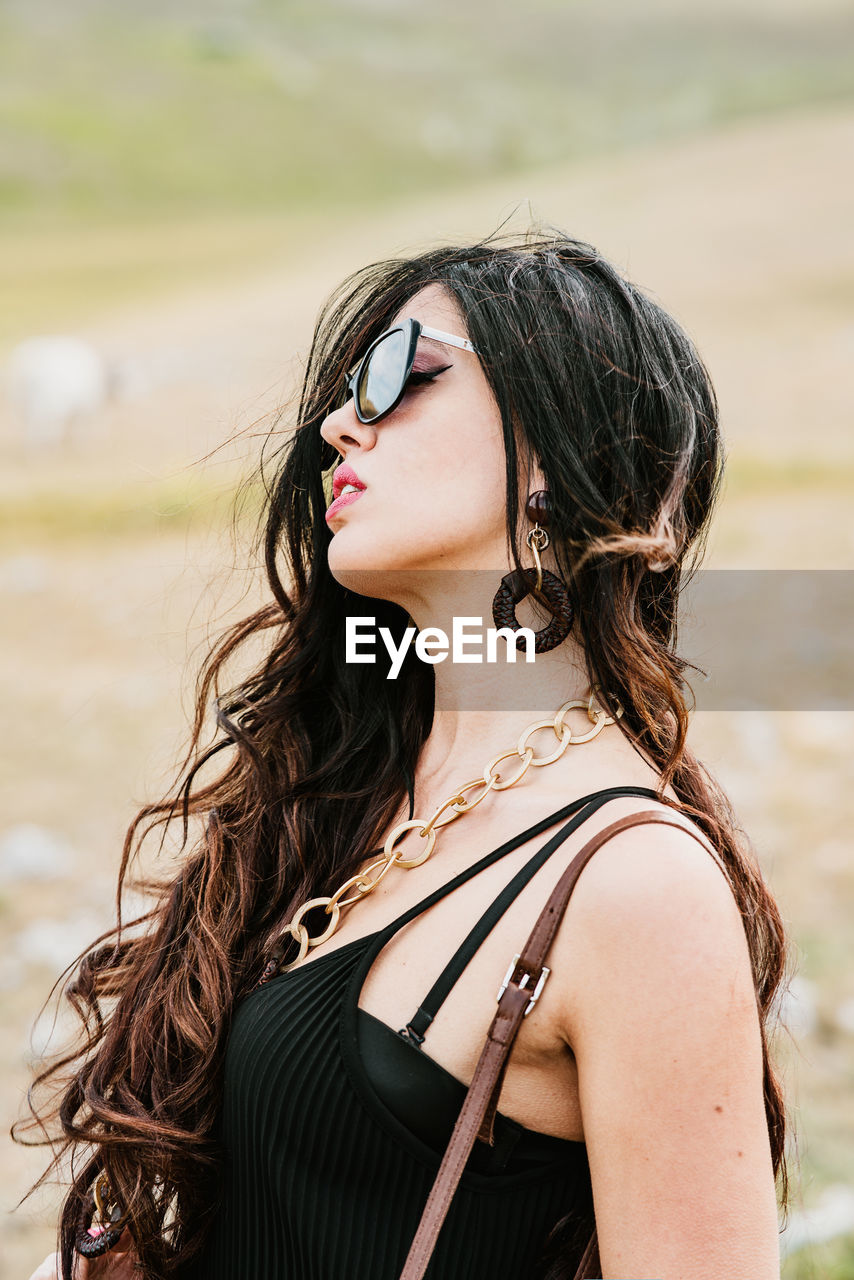 Portrait of young woman wearing sunglasses and bijoux 