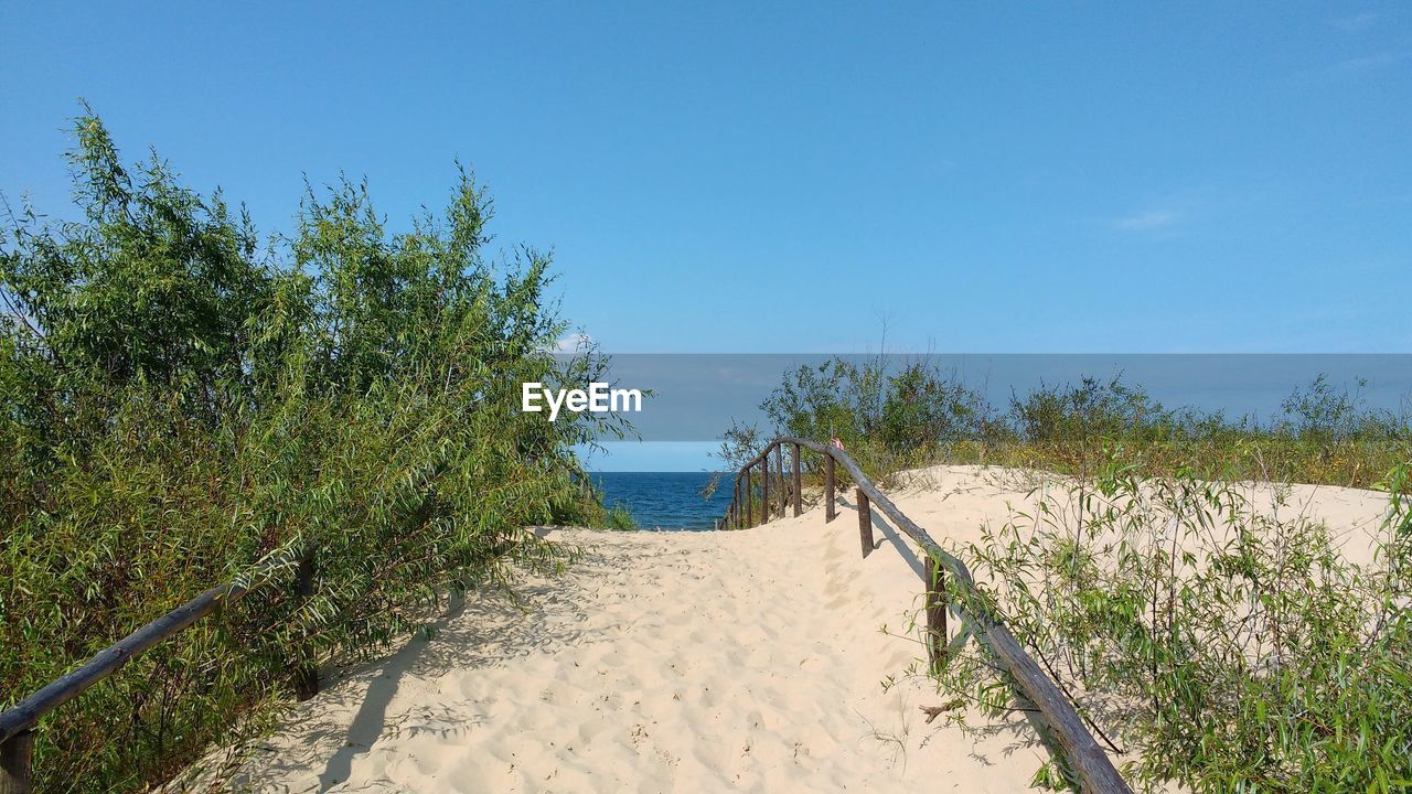 Scenic view of beach against clear blue sky