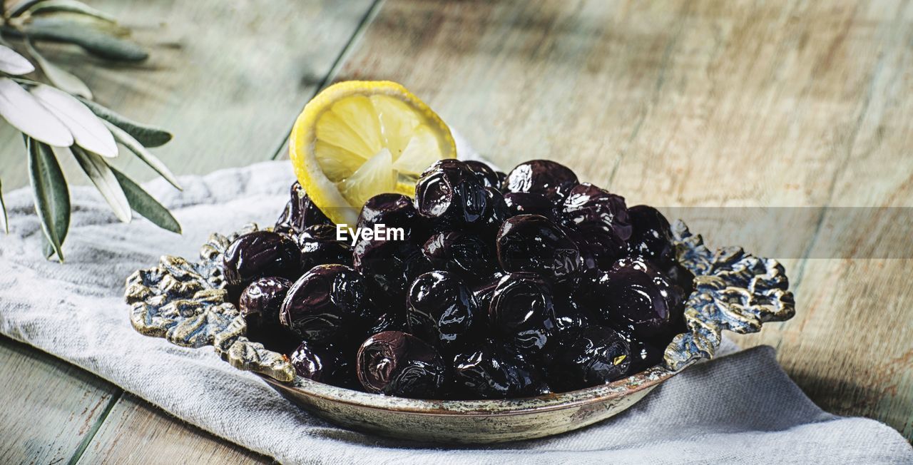 High angle view of  black olives in bowl on table