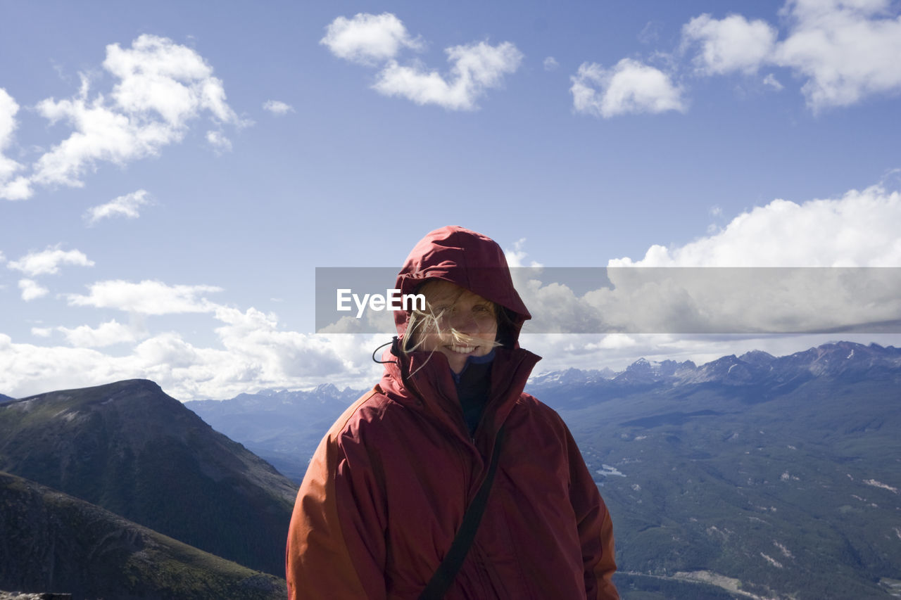 Portrait of happy woman wearing warm clothing at whistler mountain against sky