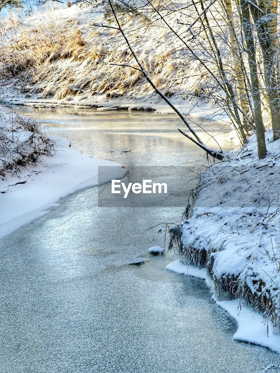 SCENIC VIEW OF RIVER BY SNOW COVERED LANDSCAPE