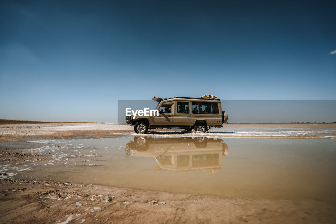Toyota landcruiser driving through puddle in the desert with reflection 2