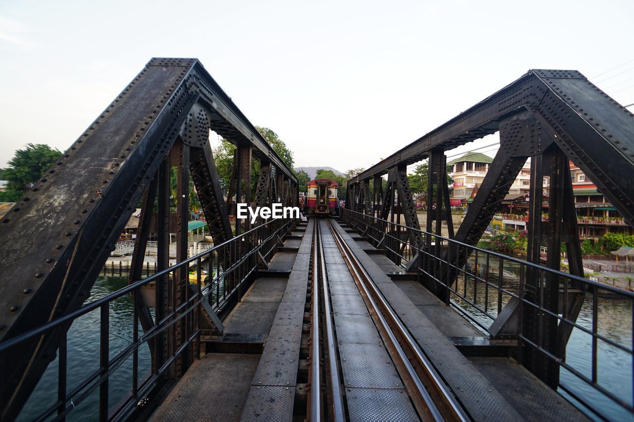 Footbridge over railroad tracks against clear sky