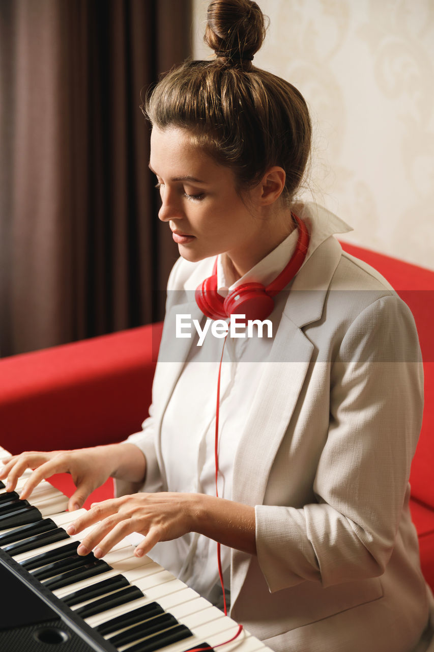 side view of young woman playing piano
