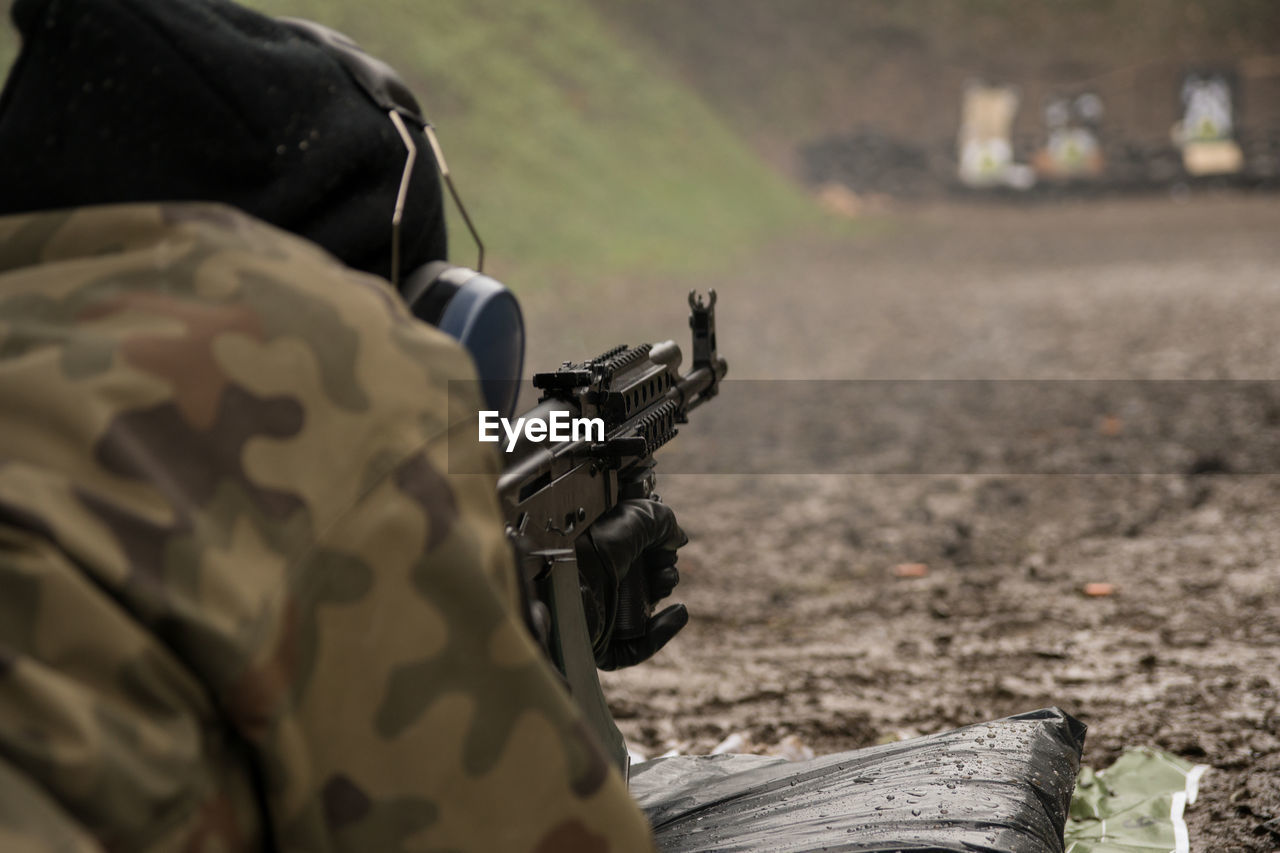 Close-up of soldier aiming rifle