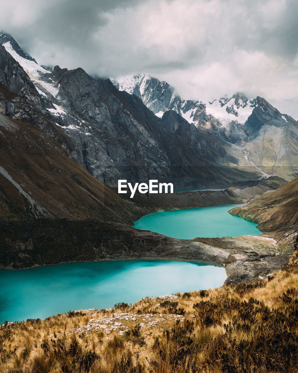 Scenic view of lake and mountains against cloudy sky