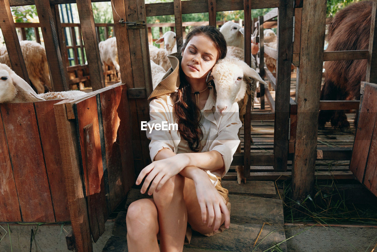 portrait of young woman sitting on wooden door