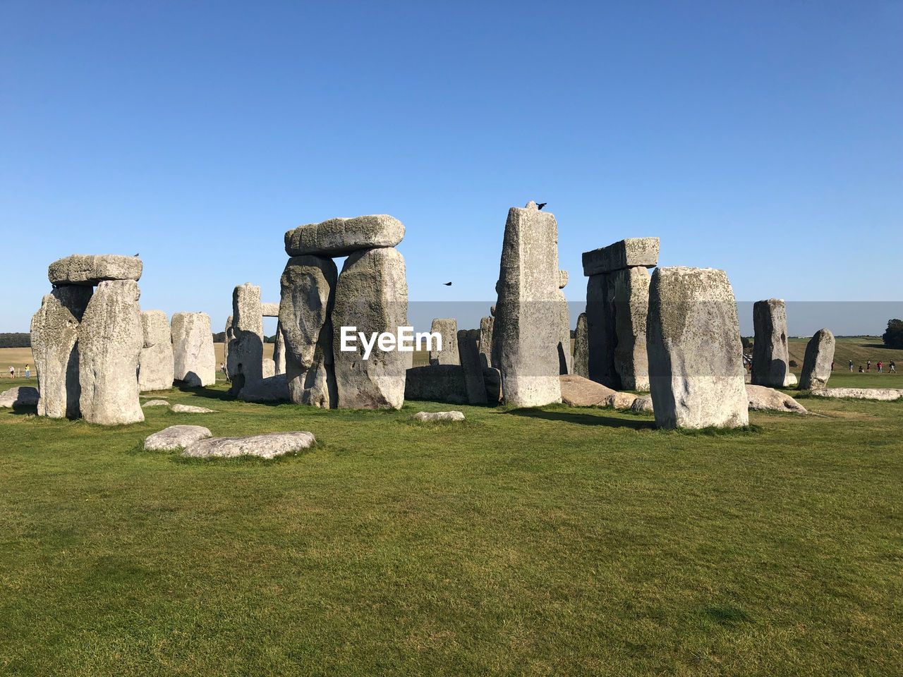 Stonehenge on field against clear sky