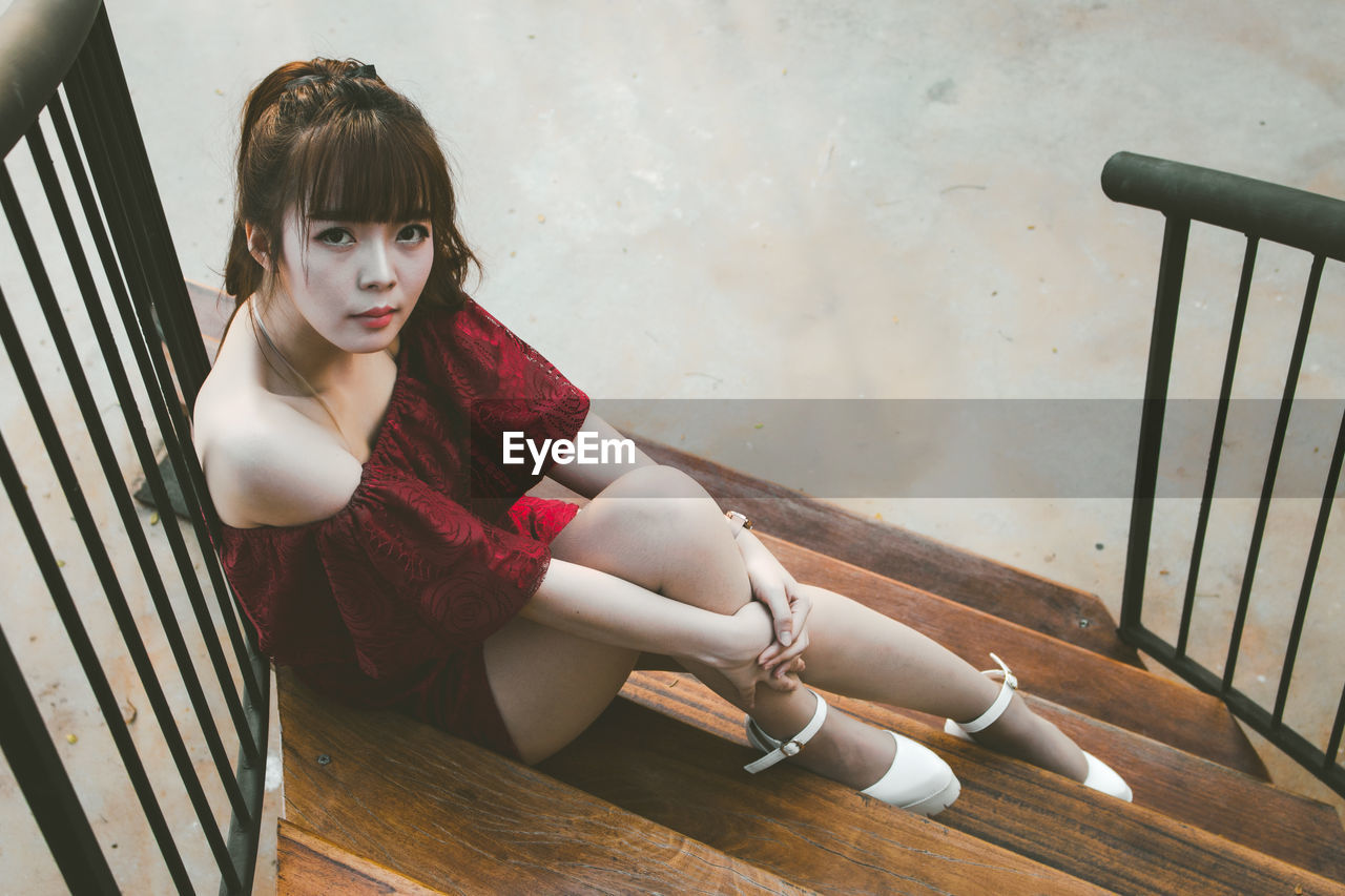 High angle portrait of beautiful woman sitting on wooden steps