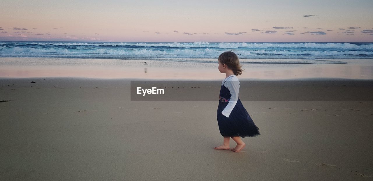 Full length of girl walking on shore at beach