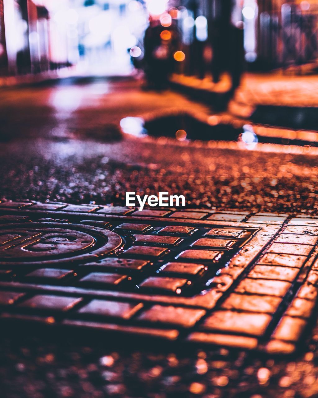 Close-up of wet street in city at night