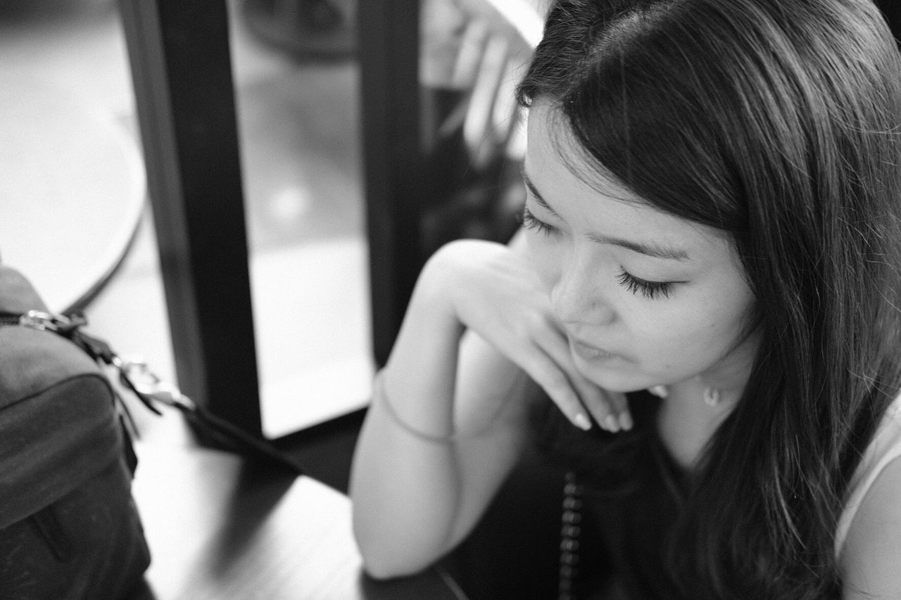 CLOSE-UP OF YOUNG WOMAN LOOKING DOWN