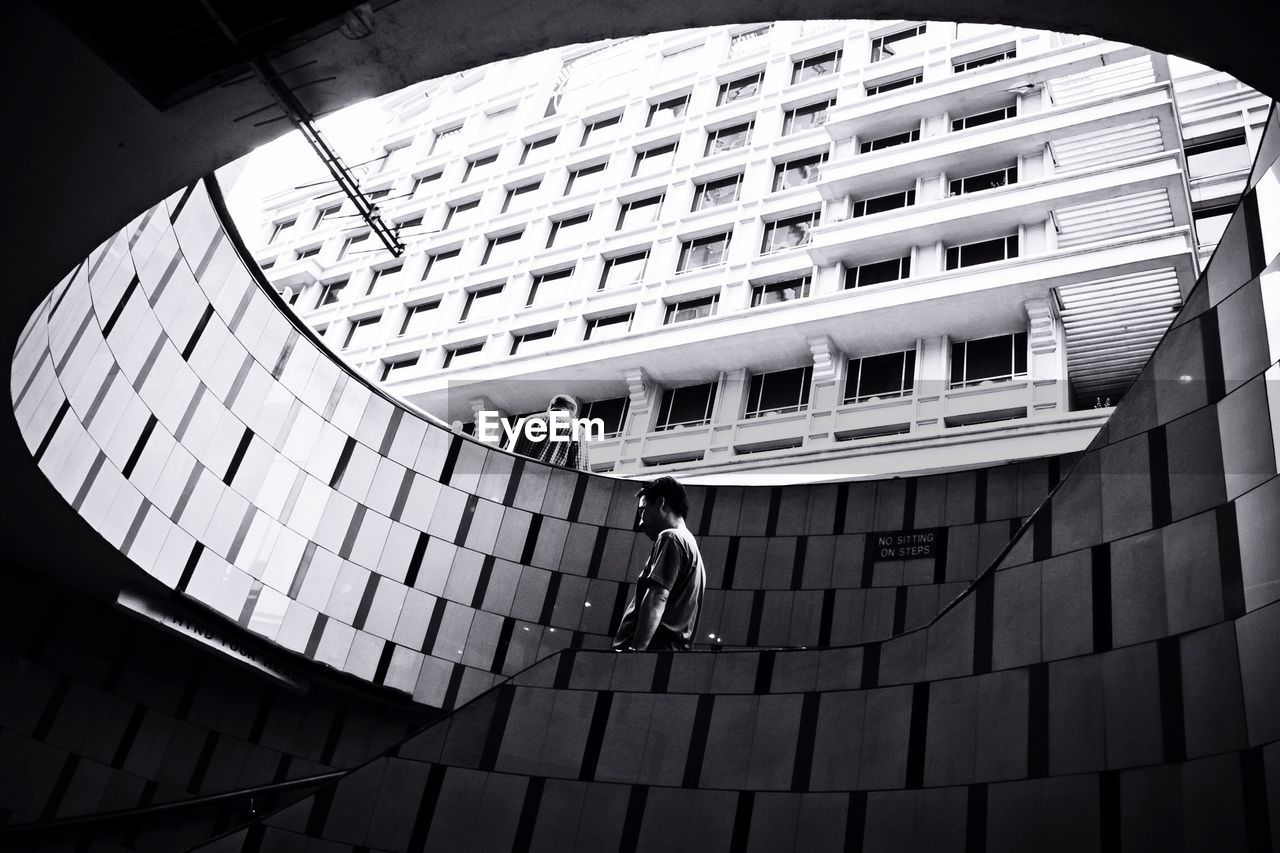 Low angle view of men on staircase of building in city