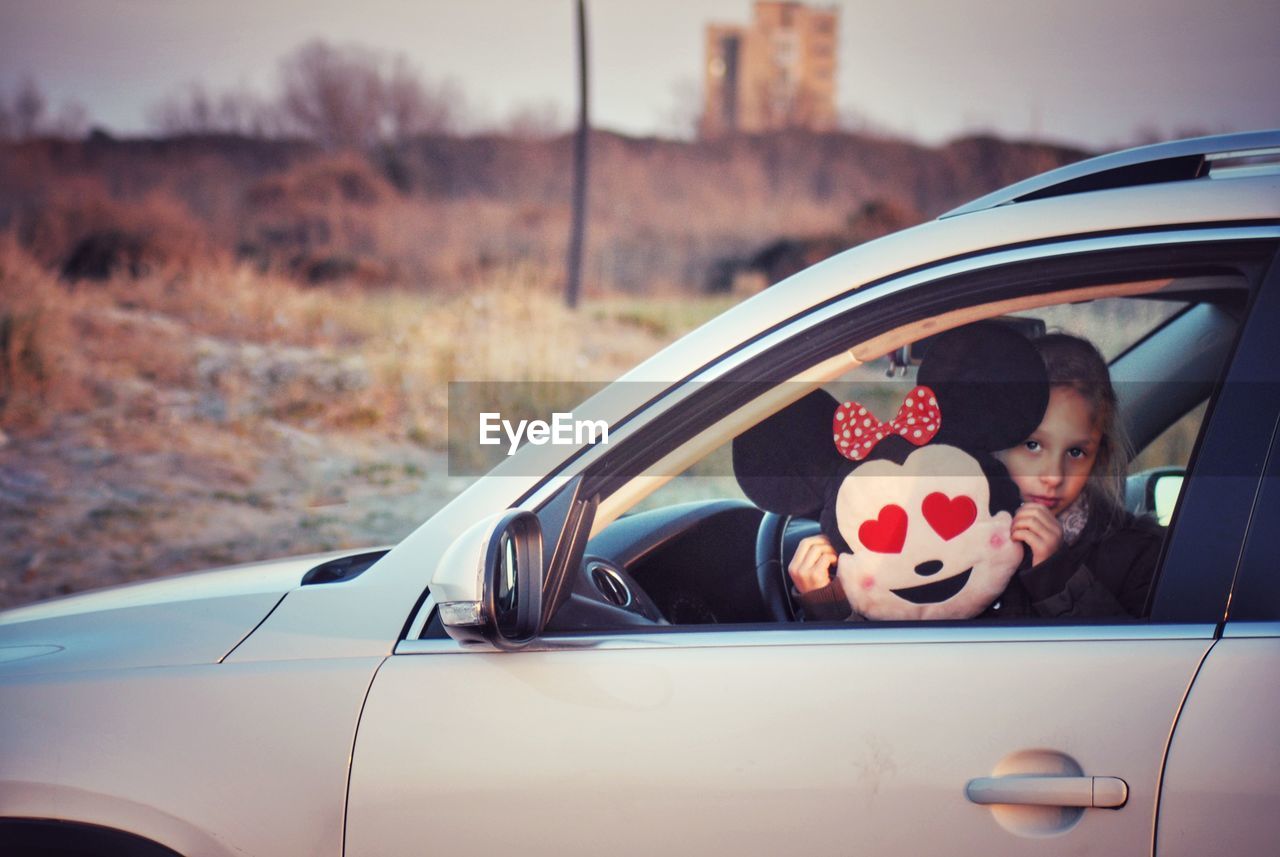 PORTRAIT OF WOMAN BY CAR WINDOW