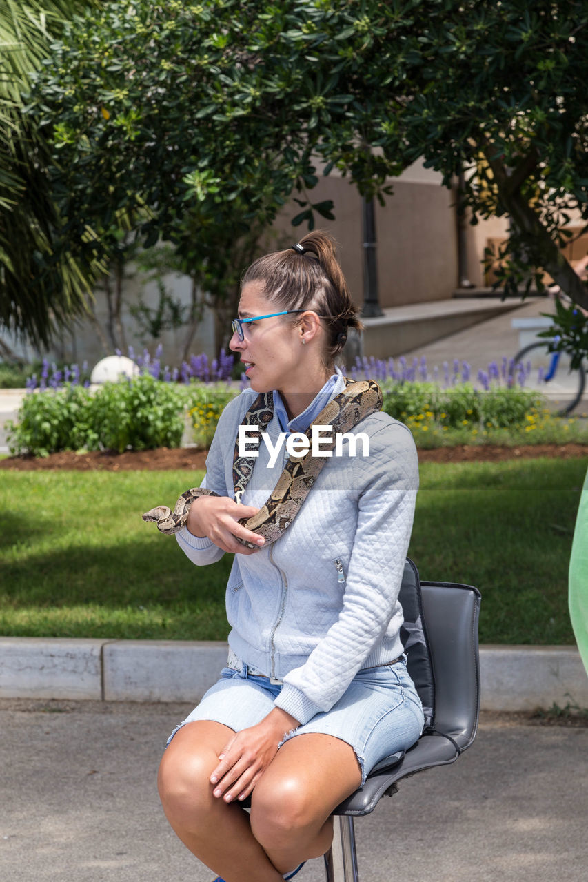 YOUNG WOMAN USING PHONE IN PARK