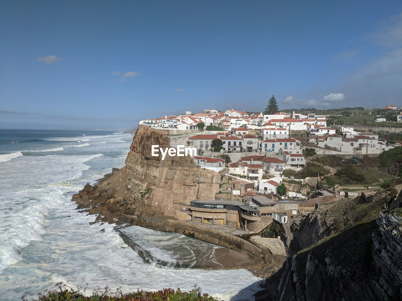 Buildings by sea against sky in city