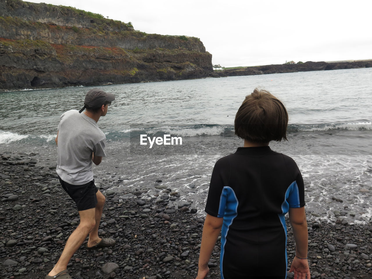REAR VIEW OF FRIENDS ON BEACH