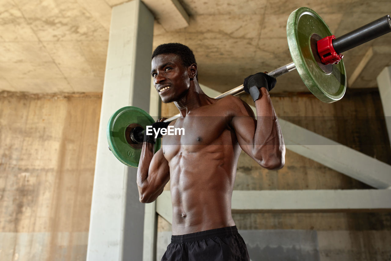 portrait of young woman exercising with dumbbells in gym