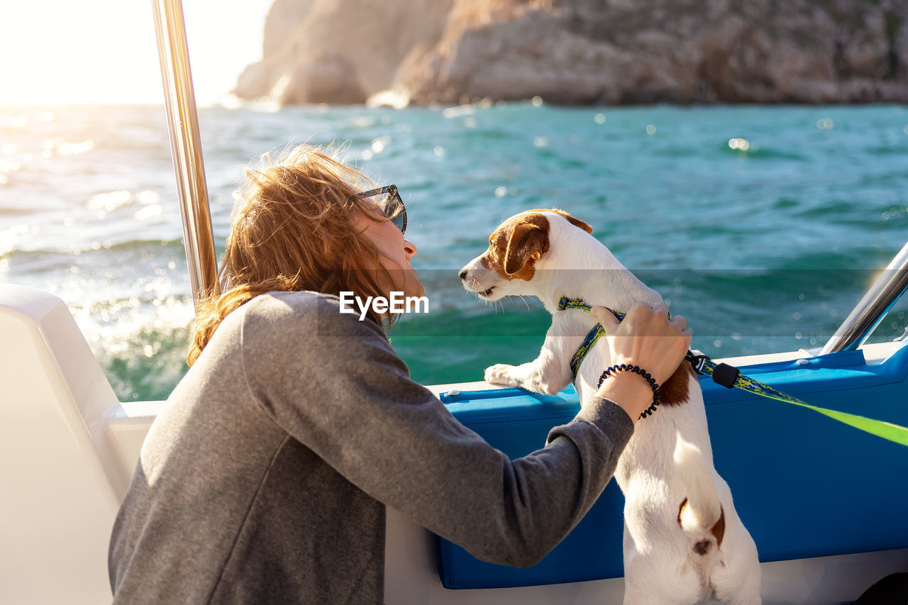 Side view of woman with dog in sea