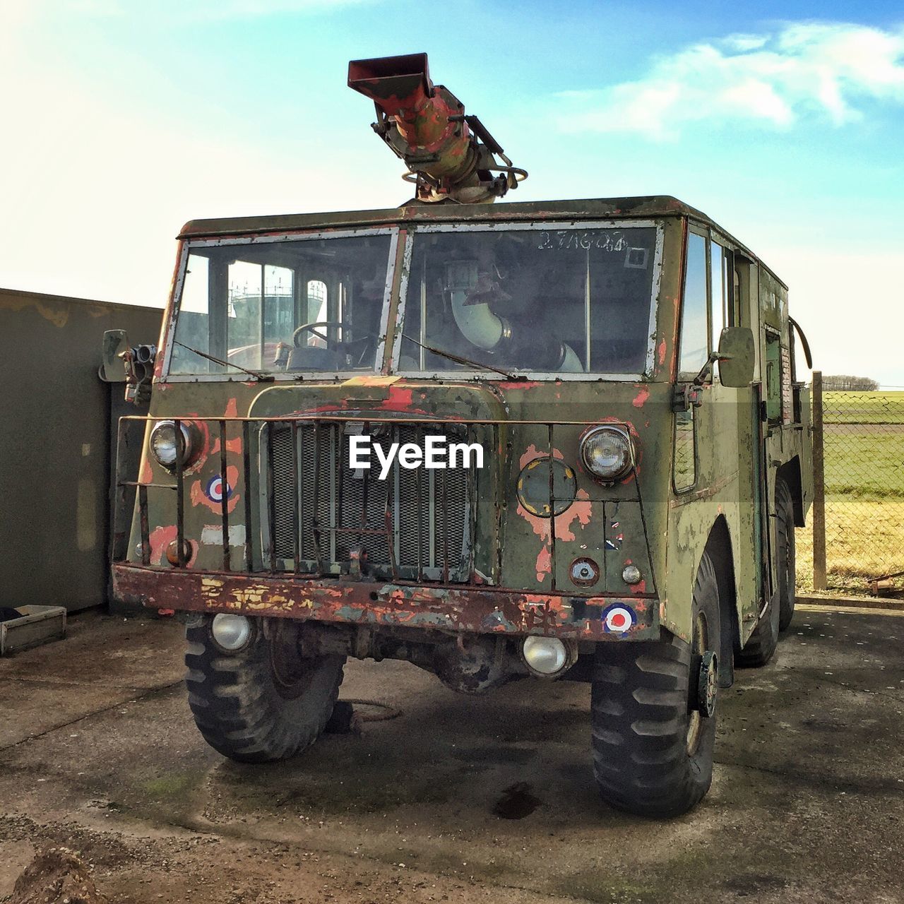 Military truck parked on field against sky