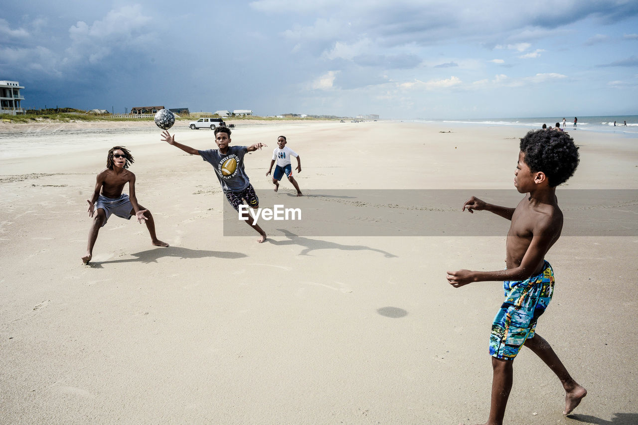 FULL LENGTH OF FRIENDS ENJOYING ON BEACH