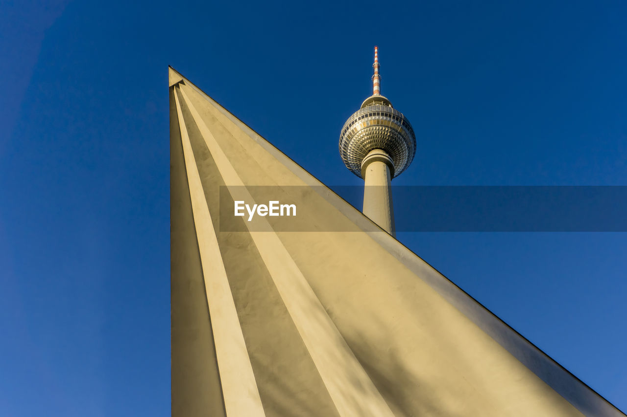 Low angle view of fernsehturm tv tower against blue sky