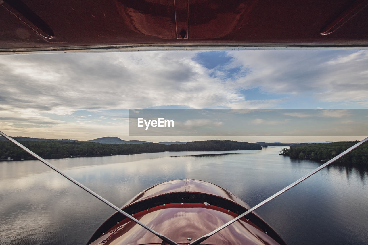 View from cockpit of vintage plane as it flies over kezar lake in main