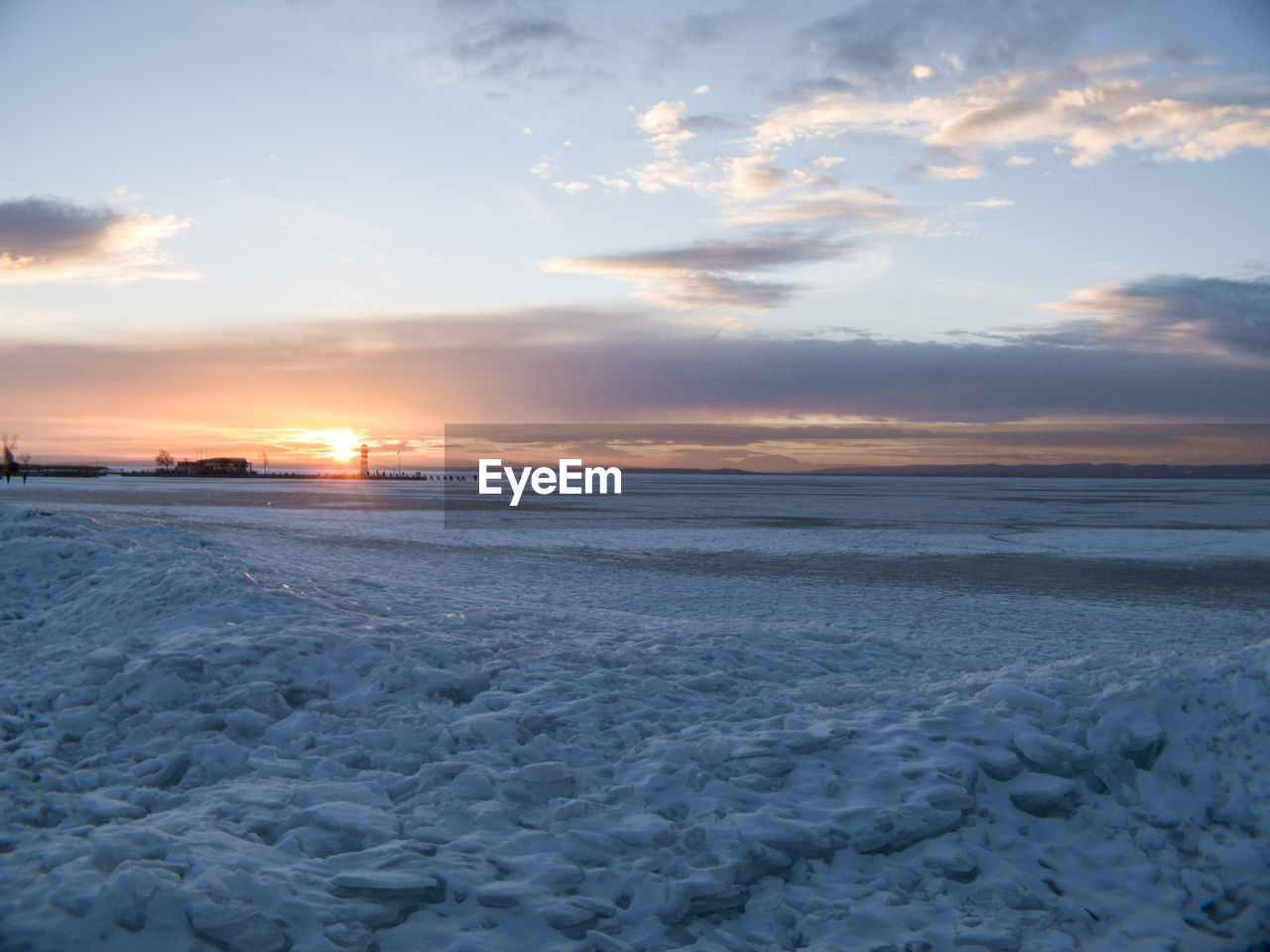 Scenic view of snow covered landscape at sunset