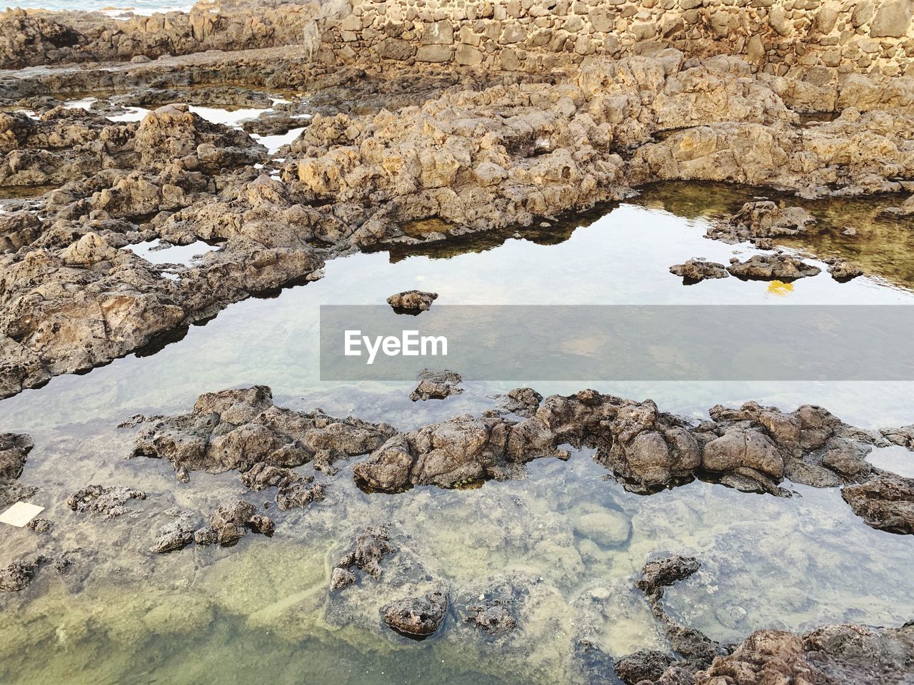 HIGH ANGLE VIEW OF ROCKS IN WATER