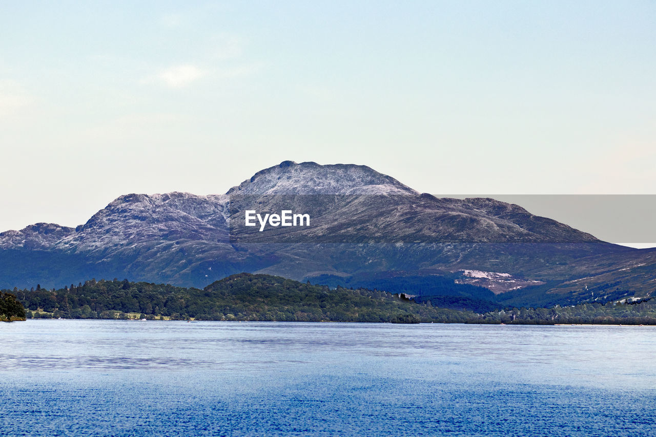 SCENIC VIEW OF SNOWCAPPED MOUNTAINS BY LAKE AGAINST SKY