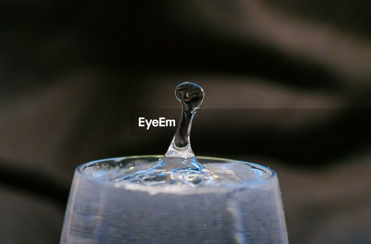 Close-up of splashing water droplet in wineglass