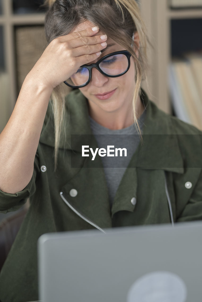 MIDSECTION OF WOMAN USING LAPTOP