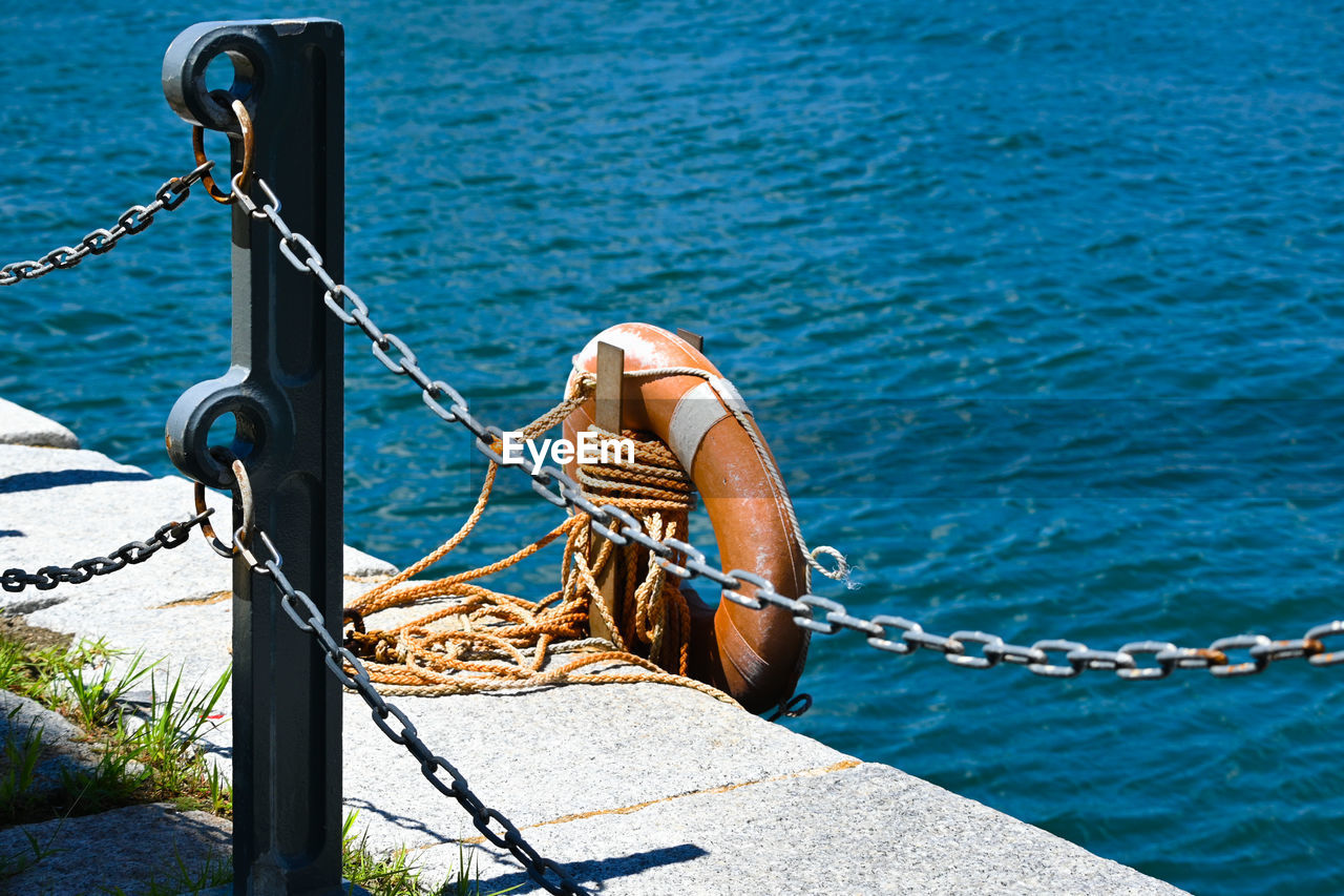 Rope tied to wooden post in sea