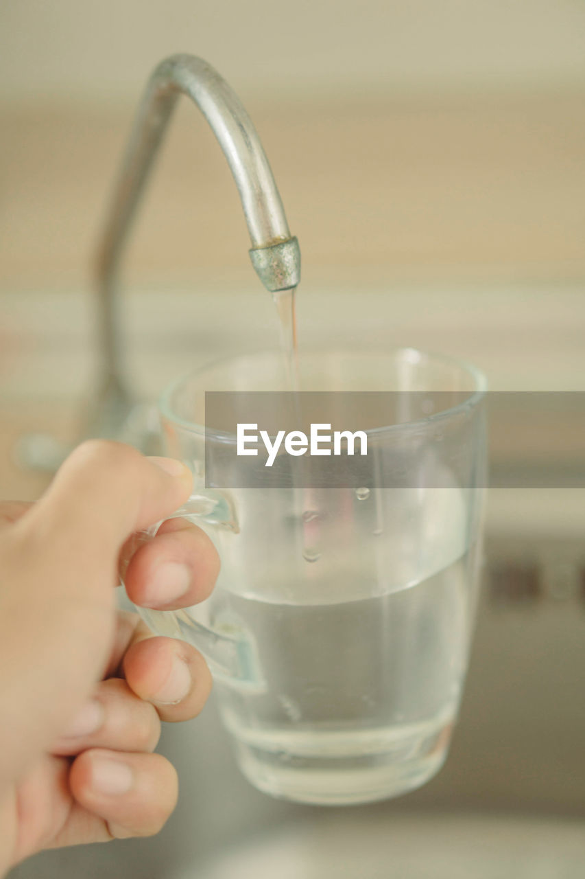 CROPPED IMAGE OF PERSON HAND POURING WATER