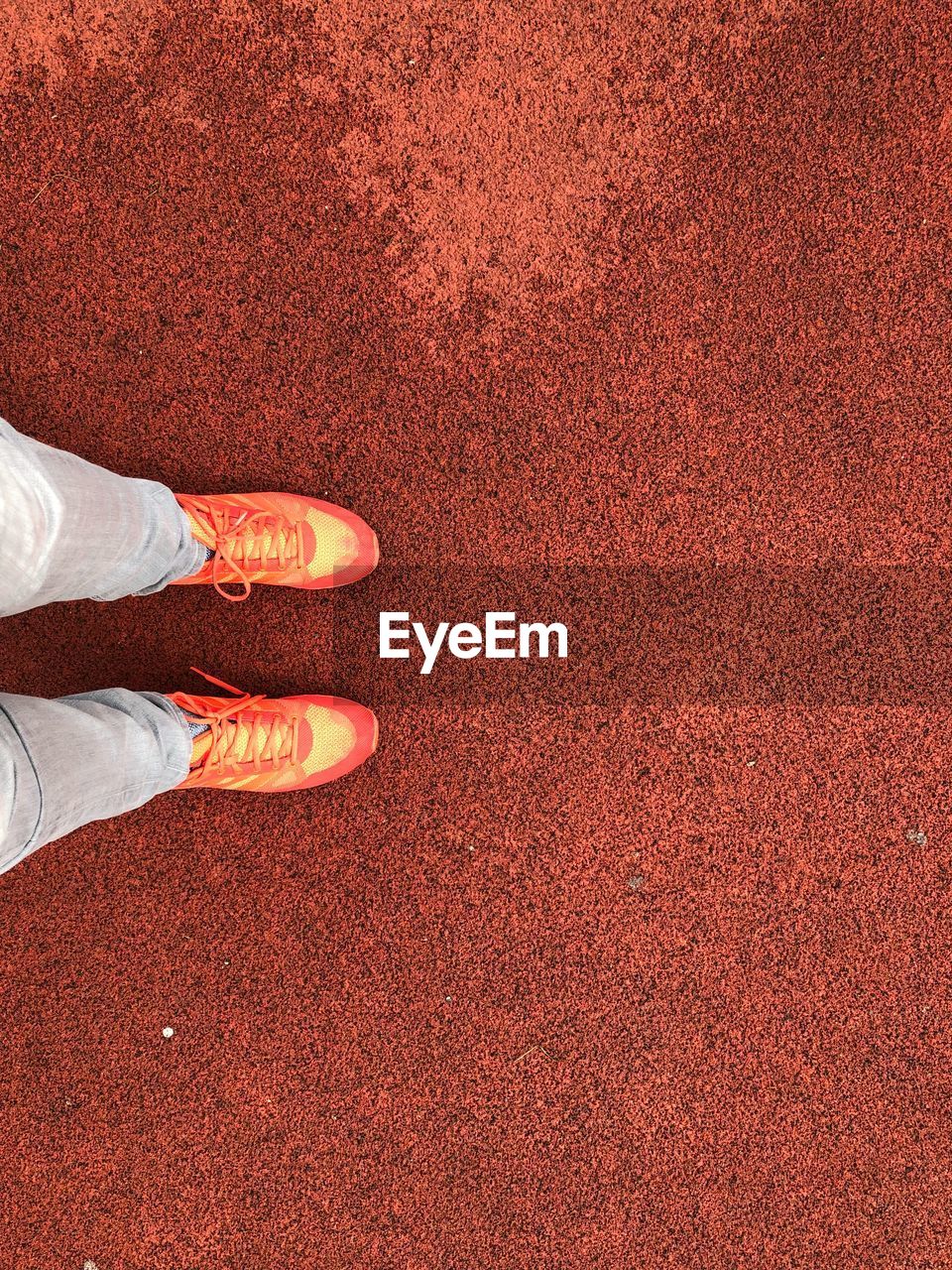 Low section of person standing on red ground